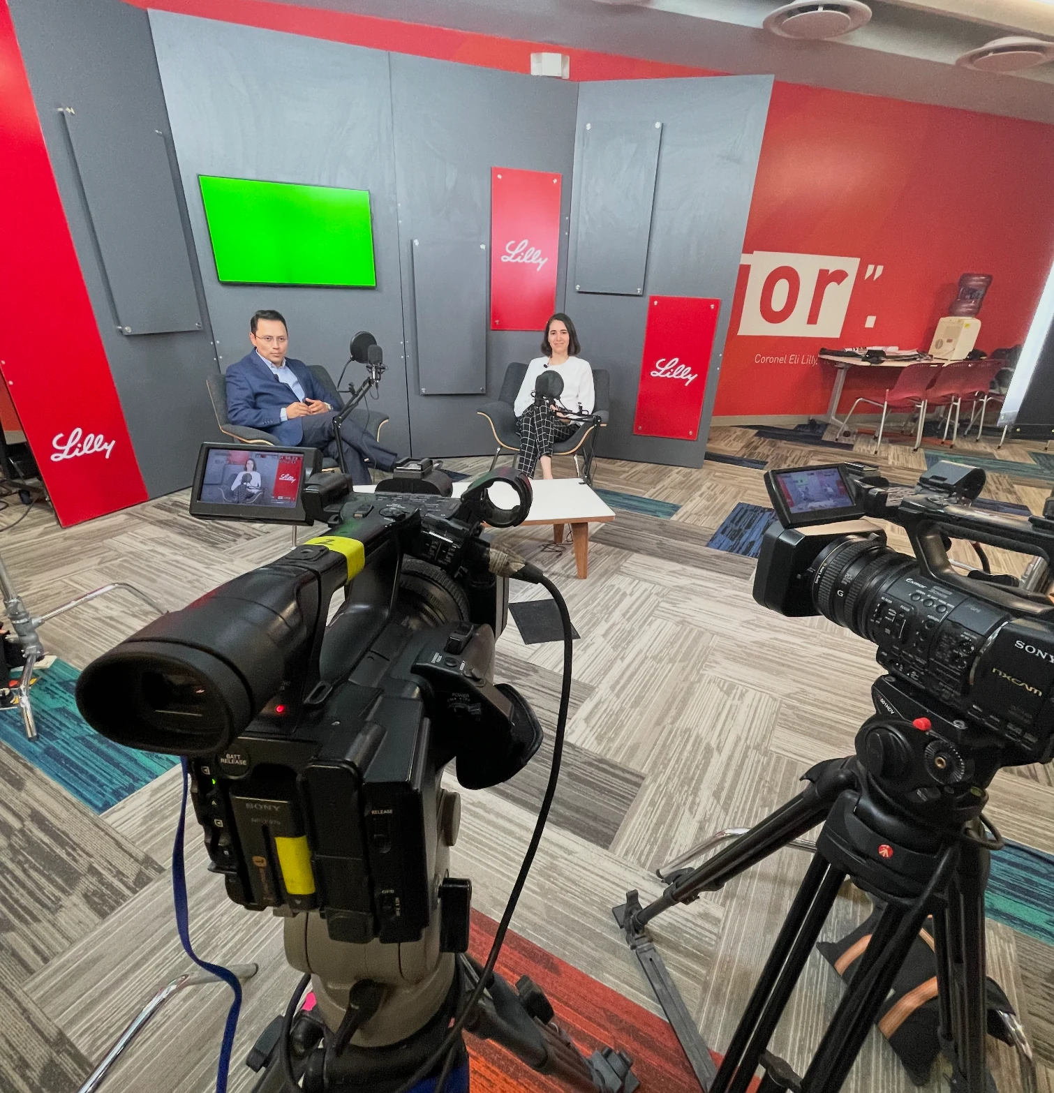 Entrevista de dos participantes frente a dos cámaras con elementos de marca Lilly