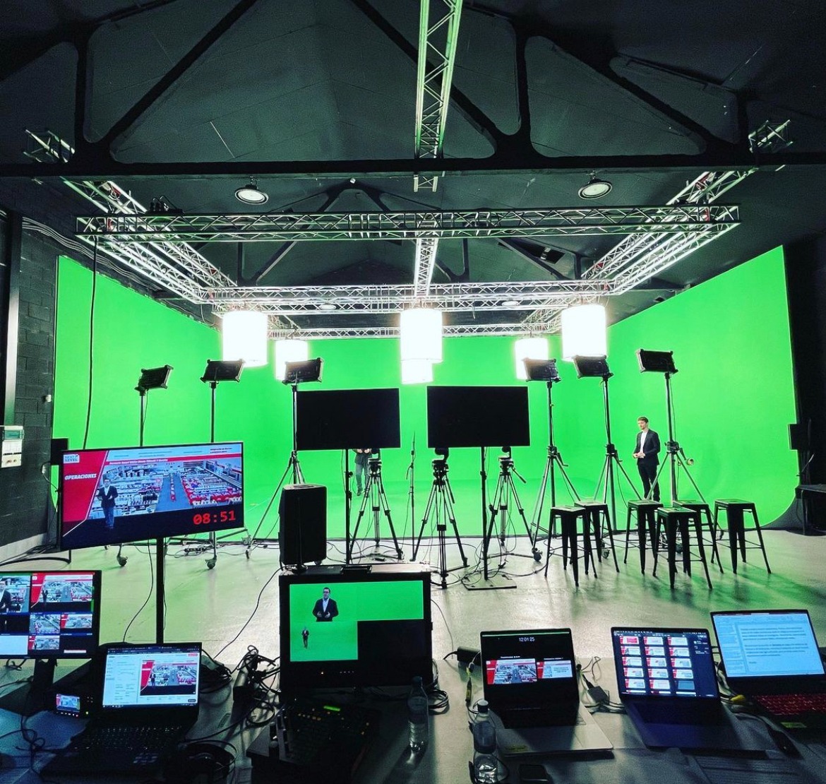 Set de grabación con ciclorama verde y monitores de control